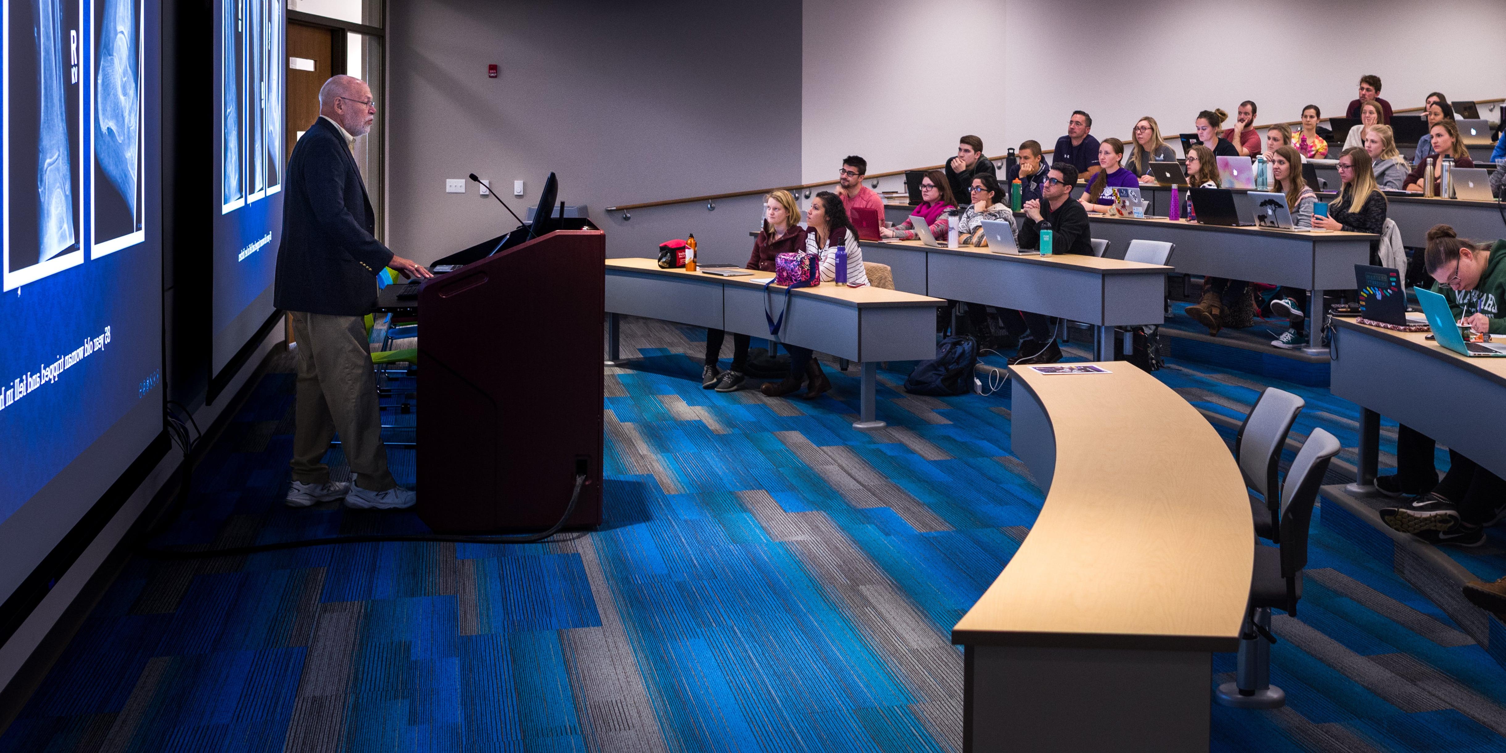 Photo of a professor teaching a classroom of Chatham University students in an auditorium at the Eastside campus. 